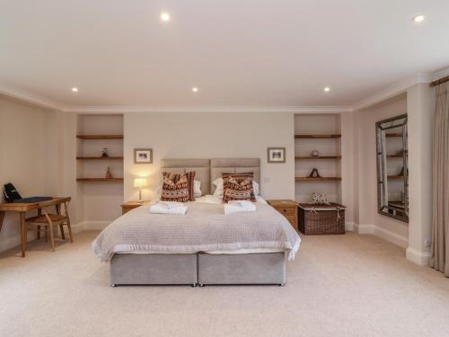 a bedroom with a bed and a desk and shelves at Blossom Hill in Witney