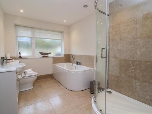 a bathroom with a tub and a toilet and a shower at Blossom Hill in Witney
