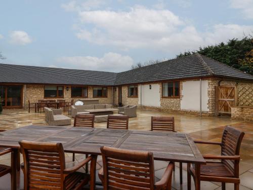 a patio with a wooden table and chairs at Blossom Hill in Witney