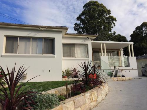 a white house with a stone retaining wall at Urban Oasis in Pendle Hills