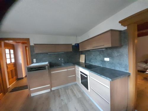 a kitchen with stainless steel appliances and wooden floors at Ferienwohnung Volz in Sankt Peter am Kammersberg