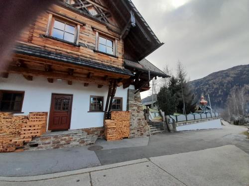 a wooden house with a door and a mountain at Ferienwohnung Volz in Sankt Peter am Kammersberg