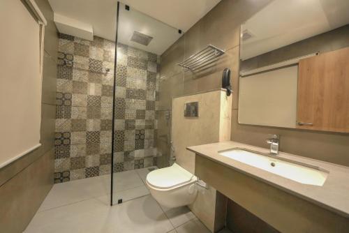 a bathroom with a toilet and a sink and a shower at Aurora Hotels and Resorts in Pulickamaly