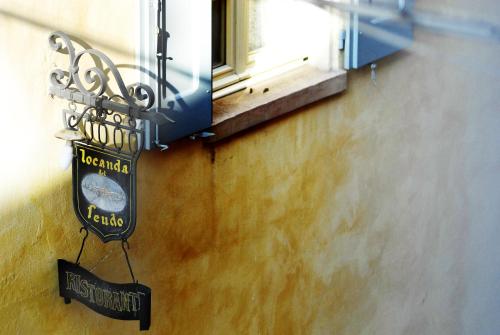 a sign for a restaurant hanging under a window at Locanda Del Feudo Suite & Restaurant in Castelvetro di Modena