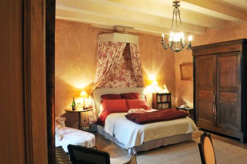 a bedroom with a bed and a chandelier at Saint Victor La Grand' Maison in Ingrandes