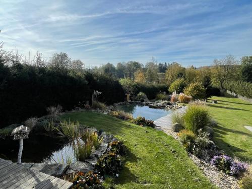 a garden with a pond in the middle of it at Log cabins at Iron Rose in Czech Canada in Nová Bystřice