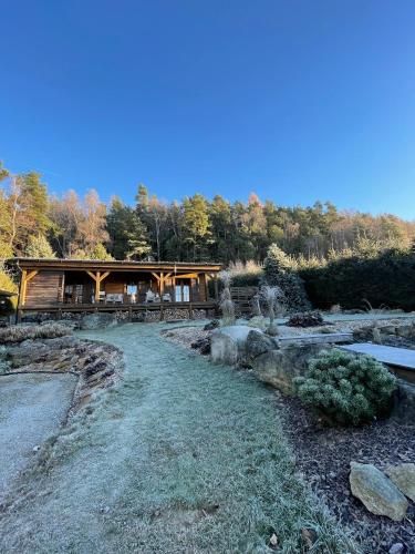 a pavilion in the middle of a garden with trees at Log cabins at Iron Rose in Czech Canada in Nová Bystřice