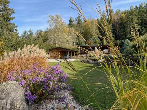a garden with purple flowers and a log cabin at Log cabins at Iron Rose in Czech Canada in Nová Bystřice