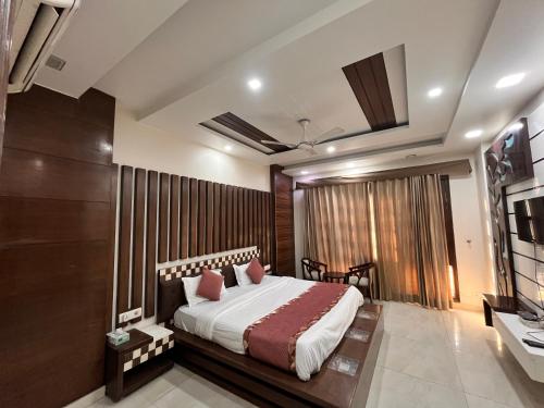 a bedroom with a large bed and a television at South Inn - Green Park South Delhi in New Delhi