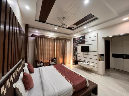 a bedroom with a large bed and a television at South Inn - Green Park South Delhi in New Delhi