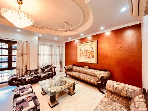 a living room with a couch and a table at South Inn - Green Park South Delhi in New Delhi