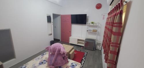 a small room with a bedroom with pink cabinets at 邱比特民宿-恆春郵局正對面 in Hengchun