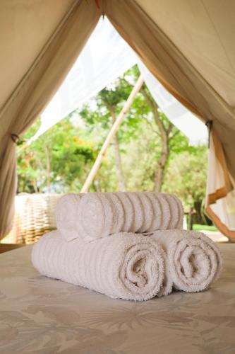 a group of towels stacked in a tent at Glamping do luxo - Tenda Curicaca in Delfinópolis