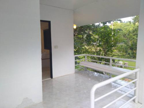 a white house with a bench on a balcony at LayTrang Pakmeng Marina Spa and Resort in Trang