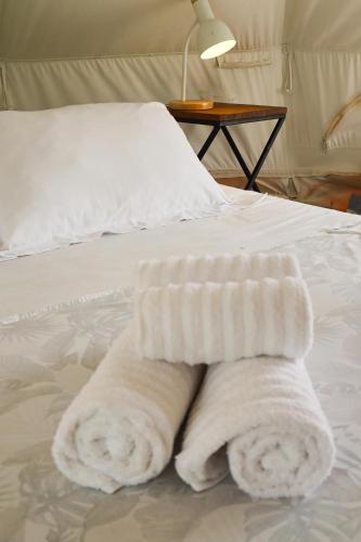 a bed with two white towels on it at Glamping do luxo - Tenda Curicaca in Delfinópolis