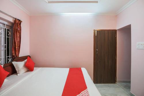 a bedroom with a bed and a wooden door at Hotel O Ma Kali Guest House in Kolkata