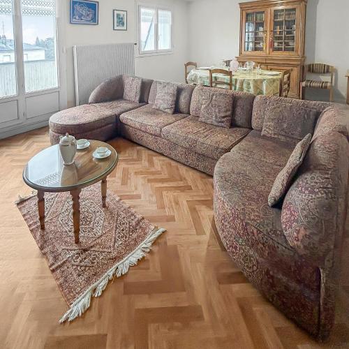 un salon avec un canapé et une table dans l'établissement StCyrSurLoire Lumineux et bien situé avec balcon & parking privé, à Saint-Cyr-sur-Loire