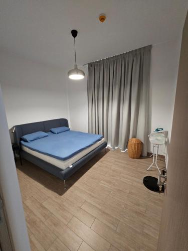 una camera da letto con un letto con lenzuola blu e una finestra di Apartment 70 m2 a Sharjah
