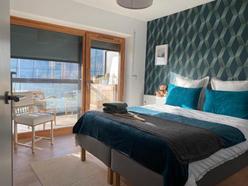 une chambre avec un lit avec des draps bleus et une fenêtre dans l'établissement Fred Appartement Lille Centre, à Lille