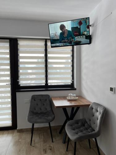 a room with a table and a tv on the wall at Casa Ana in Câmpulung Moldovenesc