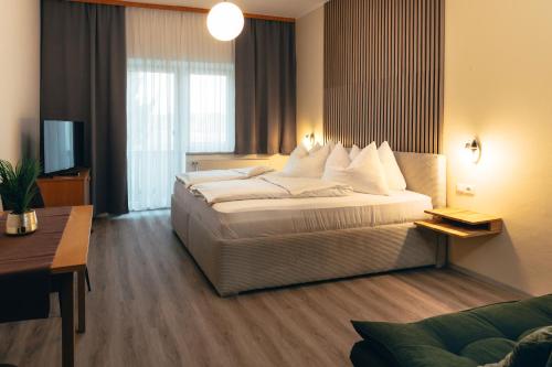 a hotel room with a large bed with white pillows at B&B Number 1 in Loipersdorf bei Fürstenfeld