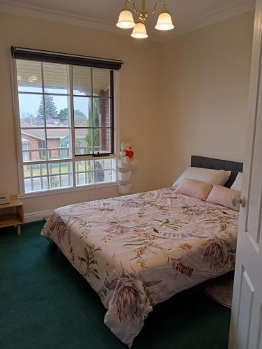 a bedroom with a bed and a large window at Federation Style 4 bedroom House with Ocean View in Lakes Entrance