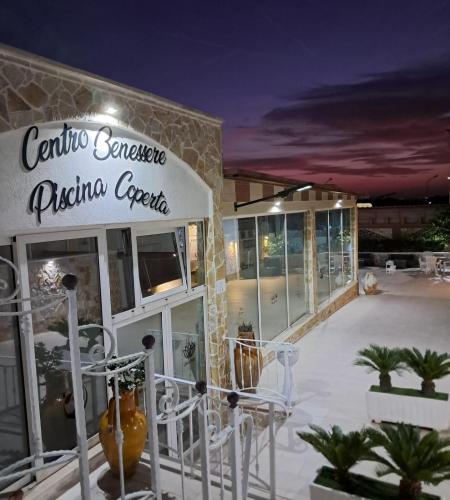 a restaurant with white chairs in front of a building at Re Sole Resort&Spa in Grottaglie
