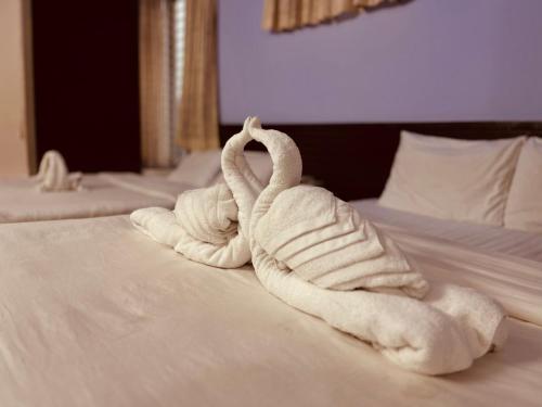 two towels are made to look like swans on a bed at Hotel Royal Palm in Sylhet