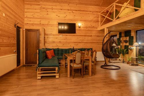 a dining room with a green couch and a table at Wooden Villa Sormoni in Tskaltubo
