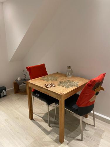 a wooden table with two chairs and a table with at DeNi's Ferienwohnungen in Klotten