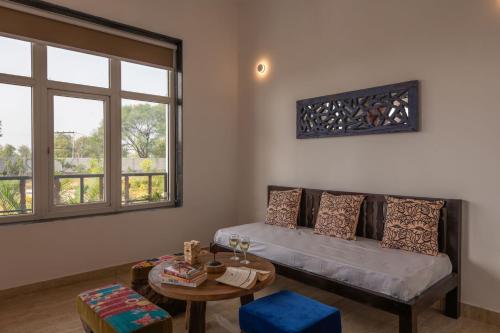 a living room with a couch and a table at Aranyavas Nature Retreat, Jaipur in Jaipur
