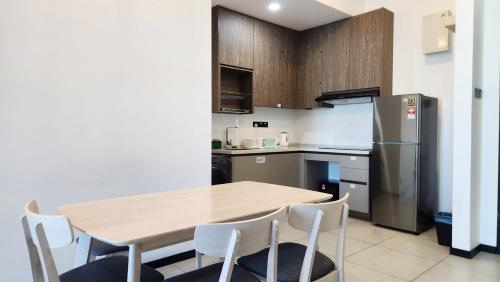 a kitchen with a wooden table and a refrigerator at Opus Residences Kuala Lumpur by Infini Suites in Kuala Lumpur