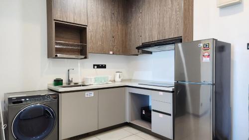 a kitchen with a stainless steel refrigerator and a dishwasher at Opus Residences Kuala Lumpur by Infini Suites in Kuala Lumpur