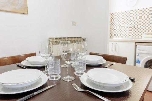 tavolo da pranzo con piatti e bicchieri di Toscanella Comfort Apartment a Firenze
