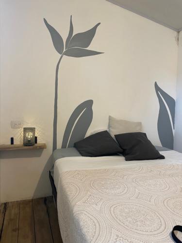 a bedroom with a bed with a wall with a tree on it at Maudie in Santa Teresa Beach
