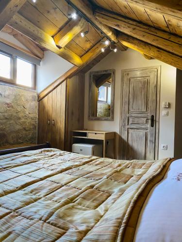 a bedroom with a large bed with a wooden ceiling at Alexandros Guesthouse in Arachova