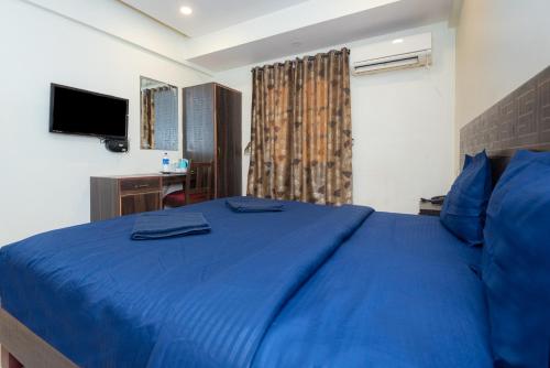a bedroom with a blue bed and a desk at HOTEL AVISHA Residency in Marmagao