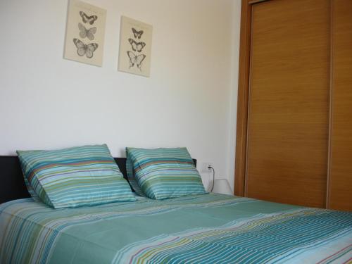 トレ・パチェコにあるMar Menor Golf Resort Rentalのベッド1台(枕2つ付)、木製クローゼットが備わります。