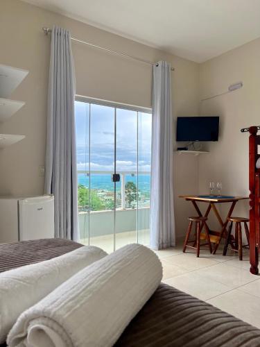 a bedroom with two beds and a view of the ocean at Pousada Aconchego De São Thomé in São Thomé das Letras