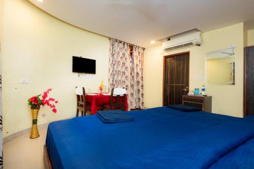 a bedroom with a blue bed and a table at HOTEL AVISHA Residency in Marmagao