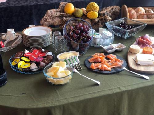 a table with plates of food on a table at Retiro dos Cedros - Quarto Vinhas in Fogueira
