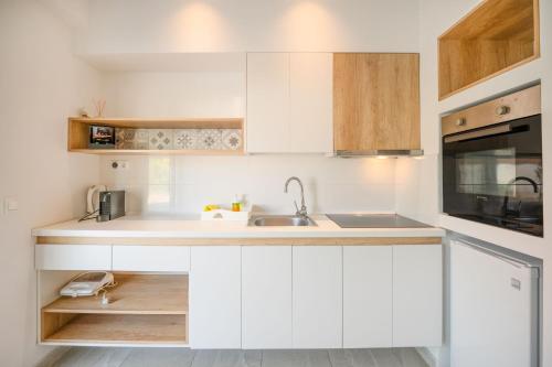 a kitchen with white cabinets and a sink at Aristi House in Olympiada