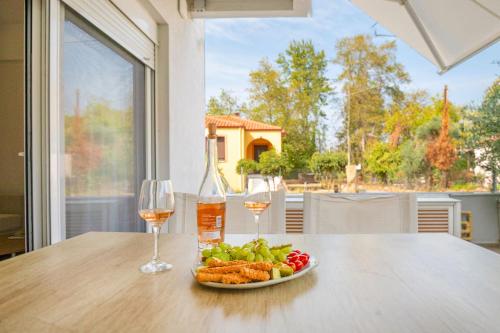 a plate of food and two glasses of wine on a table at Aristi House in Olympiada