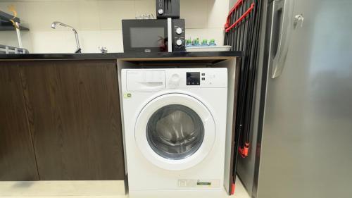 a white washing machine in a kitchen with a counter at Chic 1BR for 3 Guests - Modern Al Reem Island Retreat Near Al Reem Mall in Abu Dhabi