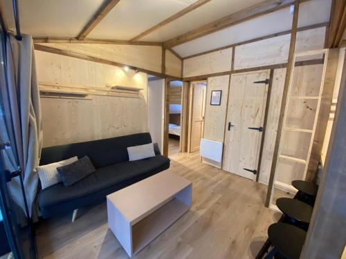 ein Wohnzimmer mit Couch und Tisch in der Unterkunft Domaine du Hygge Chalets Lodges & Spa in Anould
