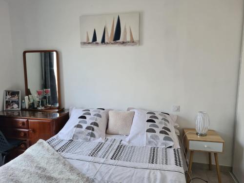 PezensにあるCharmante villa à Pezensのドレッサーと鏡付きのベッドのある寝室