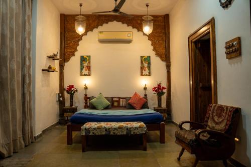 a bedroom with a bed and a chair in a room at Club Woods Villa - Gaikwads Woods Villa B12E in Purandhar