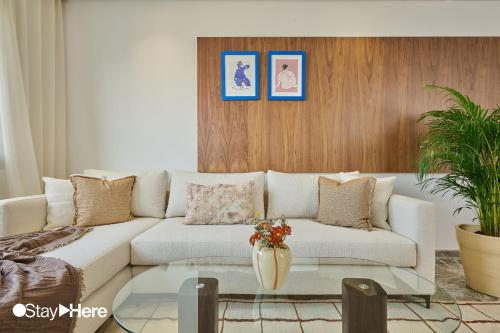 a living room with a white couch and a glass table at StayHere Casablanca - Oasis - Premium Residence in Casablanca
