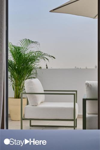 a living room with a white couch and a plant at StayHere Casablanca - Oasis - Premium Residence in Casablanca