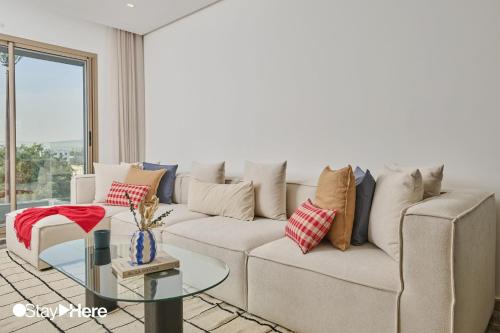 a living room with a couch and a glass table at StayHere Casablanca - Oasis - Premium Residence in Casablanca